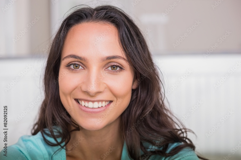 Sticker happy brunette sitting on bed