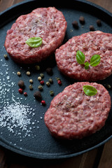 Raw beef cutlets with spices, close-up, studio shot