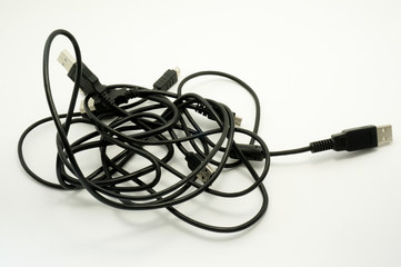 Entangled USB cables on white background