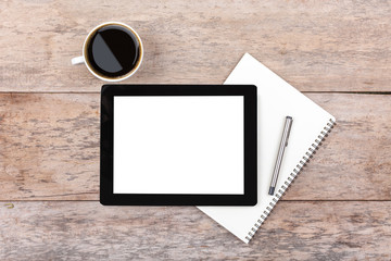 Tablet and notepad on a wooden desktop