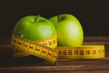 Green apples with measuring tape