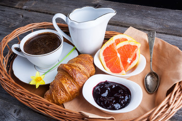 Coffee, croissant, grapefruit and jam. breakfast table
