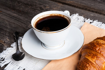 A cup of coffee and a croissant. breakfast table