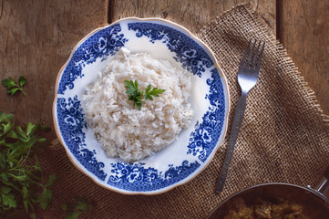 Risotto, decorated with parsley, on wooden table