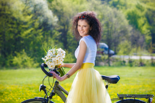 beautiful young woman with a bicycle in nature