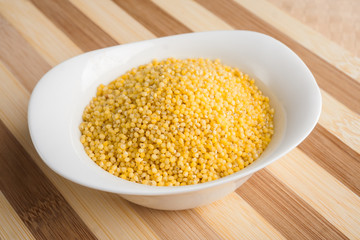 Millet groats in white bowl