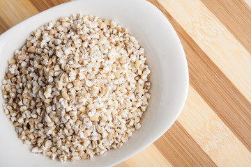 Barley groats in white bowl