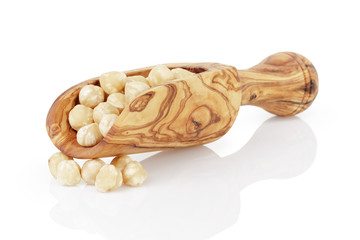 peeled and cleaned hazelnut kernels in wood scoop, isolated
