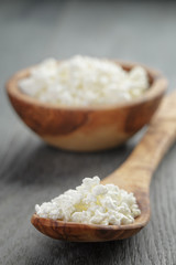 fresh cottage cheese in a wood bowl on a wooden table