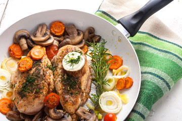 Baked chicken breast with mushrooms and carrots on the pan