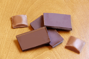 Group of chocolate pieces on wooden background. Selective focus