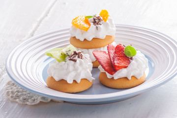 Small biscuits with fruits and whipped cream