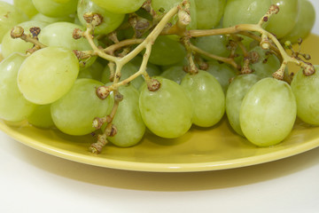 green grape comsumed on yellow plate on white screen