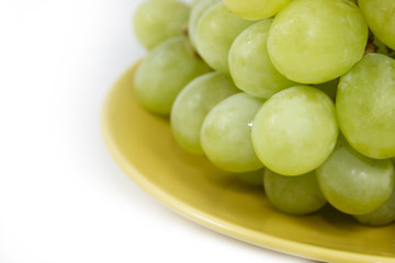 green grape on yellow plate on white screen