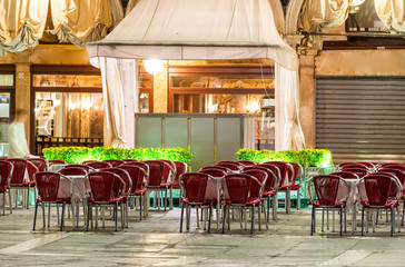 St Mark Square at night in Venice. Outdoor restaurant seats