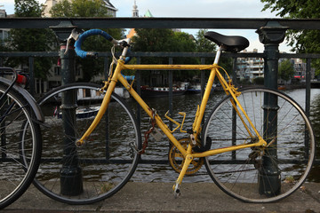 Fototapeta na wymiar Old yellow bicycle in Amsterdam, Netherlands.