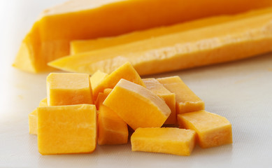 Chopped orange butternut squash on cutting board
