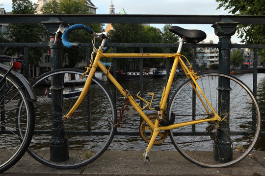 Old yellow bicycle in Amsterdam, Netherlands.