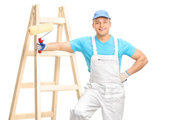 Cheerful male decorator holding a paint roller