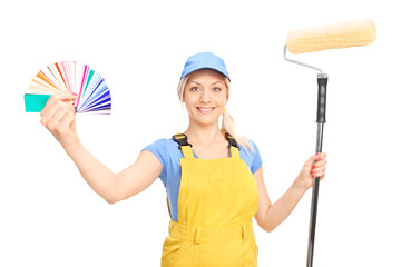 Woman holding a paint roller and a color guide