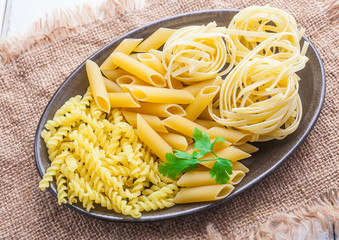 Dry pasta on a dark plate.