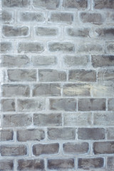 A closeup vertical image of old grey textured bricks wall.