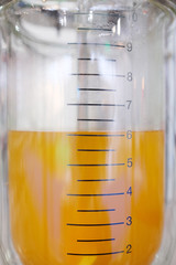 Laboratory equipment. Orange chemical substance in the beaker