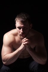 Image of shirtless man keeping his hands by face