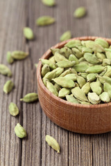 Green cardamom ayurveda asian aroma spice in a wooden bowl on vi