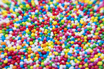 Fototapeta na wymiar Macro of Sugar colorful balls powder background