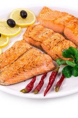 Salmon fillet on plate with lemon and peppers