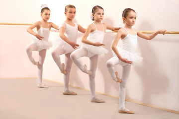 Group of four little ballerinas practicing