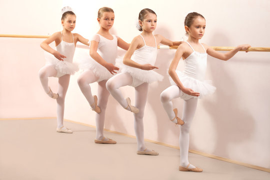 Group of four little ballerinas practicing