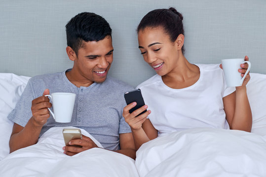 couple cellphone bed