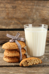 Tasty cookies and glass of milk on rustic wooden background