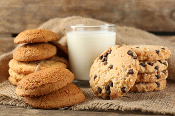 Tasty cookies and glass of milk on rustic wooden background