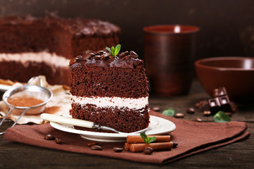 Delicious chocolate cake on table on brown background