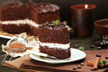 Delicious chocolate cake on table on brown background