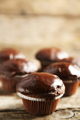 Tasty homemade chocolate muffins on wooden table