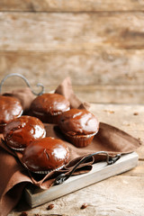 Tasty homemade chocolate muffins on wooden table