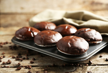 Tasty homemade chocolate muffins on wooden table