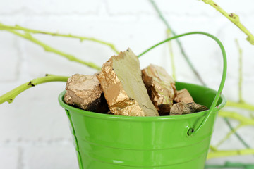 Gold in bucket on brick wall background