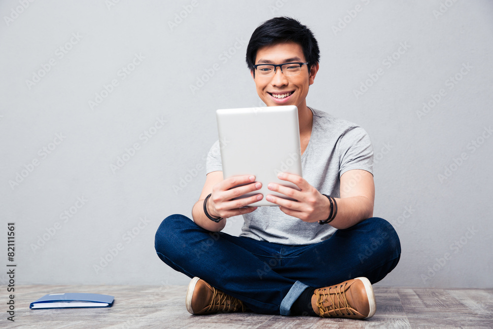 Sticker Smiling asian man using tablet computer