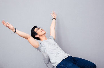 Happy asian man dreaming over gray background