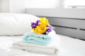 Fototapeta na wymiar Colorful beautiful freesias on fresh towels in hotel, close up