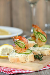 Appetizer canape with shrimp and cucumber on table close up