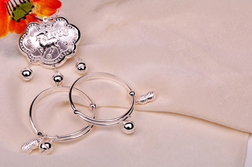 Silver Lock and Silver Bracelets on White Silk