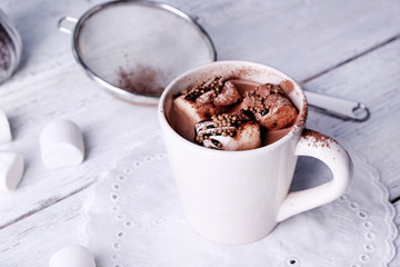 Cup of cocoa with marshmallows on wooden background