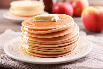 Delicious pancakes with honey on plate on table close-up