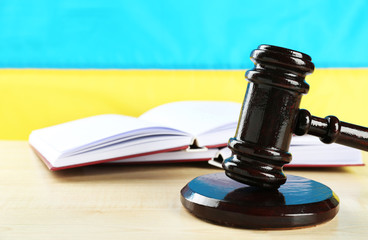 Wooden gavel and flag of Ukraine as background